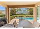 Covered patio with furniture overlooks the pool and spa with manicured landscaping at 480 Lasso Dr, Kissimmee, FL 34747