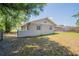 Backyard view of the home with a fence and mature trees in a residential setting at 4827 Elese St, Orlando, FL 32811