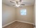 This bedroom features a ceiling fan, a window with blinds, neutral paint, and vinyl flooring at 4827 Elese St, Orlando, FL 32811