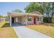 Cozy home featuring stone accents, a red door, and an attached carport with covered parking at 4827 Elese St, Orlando, FL 32811