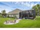 Backyard features a fire pit, pool with screened enclosure, and well-maintained lawn at 5025 Down Point Ln, Windermere, FL 34786
