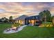 Beautiful backyard with a fire pit, lush lawn, and a screened-in pool area, perfect for outdoor enjoyment at 5025 Down Point Ln, Windermere, FL 34786