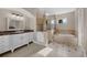 Bright bathroom featuring a double vanity, a separate shower, and a built-in tub, tiled in neutral colors at 5025 Down Point Ln, Windermere, FL 34786
