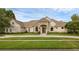Daytime exterior of attractive one-story home with stone accents, manicured lawn, and tile roof at 5025 Down Point Ln, Windermere, FL 34786
