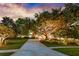 Sprawling front yard with mature trees, lush landscaping and elegant exterior lighting at 5025 Down Point Ln, Windermere, FL 34786