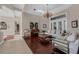 Elegant living room with hardwood floors, chandelier, piano, and lots of natural light at 5025 Down Point Ln, Windermere, FL 34786