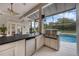 This outdoor kitchen has stainless steel appliances including a built-in grill and refrigerator at 5025 Down Point Ln, Windermere, FL 34786