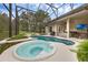 Inviting screened-in pool and spa with outdoor kitchen and bar area, perfect for entertaining at 5025 Down Point Ln, Windermere, FL 34786