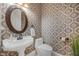 Stylish powder room with decorative wallpaper, pedestal sink, and elegant fixtures at 5025 Down Point Ln, Windermere, FL 34786