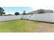 Beautiful shot of green backyard with healthy grass and newly installed white vinyl fence for privacy at 5089 Meadow Song Dr, Okahumpka, FL 34762