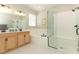 Bright bathroom with dual sinks, separate shower, and tub featuring white tile finishes at 5089 Meadow Song Dr, Okahumpka, FL 34762