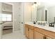 Well-lit bathroom with dual vanities, wood cabinets, and hexagon tile flooring at 5089 Meadow Song Dr, Okahumpka, FL 34762