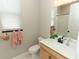Bright bathroom featuring a modern sink, toilet, and decorative hand towels at 5089 Meadow Song Dr, Okahumpka, FL 34762