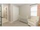 Cozy Bedroom showcasing a white rocking chair, soft natural light, and neutral decor at 5089 Meadow Song Dr, Okahumpka, FL 34762