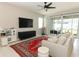Cozy living room with a large TV, couch, and sliding door access to outdoor patio at 5089 Meadow Song Dr, Okahumpka, FL 34762