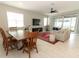 Open-concept living space with dining area, TV, and sliding glass doors to the patio at 5089 Meadow Song Dr, Okahumpka, FL 34762