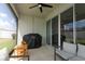 View of screened lanai features ceiling fan, grill, and glass sliding doors to the inside of the home at 5089 Meadow Song Dr, Okahumpka, FL 34762