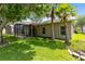 Landscaped backyard features a screened lanai and mature palm trees at 516 Brett Ct, Orlando, FL 32828