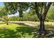 Secluded backyard with well manicured lawn and small pond surrounded by mature trees, giving natural privacy at 516 Brett Ct, Orlando, FL 32828
