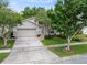 Charming single-Gathering home featuring a well-manicured lawn, mature landscaping, and a two-car garage at 516 Brett Ct, Orlando, FL 32828