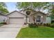 Charming single-Gathering home with a well-maintained lawn, flowering shrubs, and a two-car garage at 516 Brett Ct, Orlando, FL 32828
