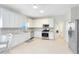 Bright kitchen with white cabinets, stainless steel appliances, tile backsplash, and neutral tile floors at 516 Brett Ct, Orlando, FL 32828