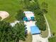 Overhead shot of community playground featuring swings, slides, and covered picnic area amid mature trees at 516 Brett Ct, Orlando, FL 32828