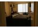 Simple bedroom with a gray comforter, natural light from a large window, and minimal decor at 518 W Plantation Blvd, Lake Mary, FL 32746