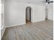 Bedroom with light wood floors, ceiling fan, and an arched doorway, creating a modern feel at 520 Stonewall Ave, Haines City, FL 33844