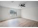 Bright bedroom featuring light wood floors, a ceiling fan, and a window with backyard views at 520 Stonewall Ave, Haines City, FL 33844