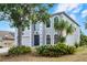 Two-story home showcasing arched windows, mature trees, and lush, green landscaping at 520 Stonewall Ave, Haines City, FL 33844