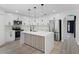 Modern kitchen features white cabinets, stainless steel appliances, an island with wooden accents and pendant lighting at 520 Stonewall Ave, Haines City, FL 33844