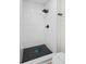 Modern shower with white tile and black honeycomb floor tile and matte hardware at 520 Stonewall Ave, Haines City, FL 33844