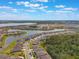 Community aerial showcasing homes around a lake, surrounded by trees, with community features visible in the distance at 5226 Northern Flicker Dr, St Cloud, FL 34771
