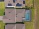 An aerial view of rooftops with pools and a manicured lawn, showcasing home design from a bird's eye perspective at 5226 Northern Flicker Dr, St Cloud, FL 34771