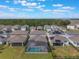 Aerial view of homes with screened pools and solar panels, with a lush green space visible in the background at 5226 Northern Flicker Dr, St Cloud, FL 34771