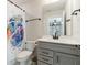 Clean bathroom with a gray vanity, quartz countertop, and decorative shower curtain at 5226 Northern Flicker Dr, St Cloud, FL 34771