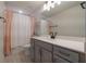 Modern bathroom featuring a gray vanity, quartz countertop, and decorative shower curtain at 5226 Northern Flicker Dr, St Cloud, FL 34771