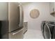 Modern laundry room featuring stainless steel appliances and neutral decor with a front-loading washer and dryer at 5226 Northern Flicker Dr, St Cloud, FL 34771