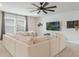 Bright living room featuring a large sofa, a ceiling fan, and modern entertainment setup at 5226 Northern Flicker Dr, St Cloud, FL 34771