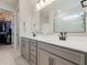 Bright main bathroom with double sink vanity, neutral walls, tile floor, and walk-in closet access at 5226 Northern Flicker Dr, St Cloud, FL 34771