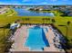 Resort-style community pool with ample seating and palm trees, overlooking a tranquil lake and neighborhood at 5226 Northern Flicker Dr, St Cloud, FL 34771