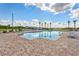 Community pool with ample seating, lush greenery, and serene lake views in a picturesque setting at 5226 Northern Flicker Dr, St Cloud, FL 34771