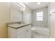 A pristine bathroom featuring marble-style tile, granite vanity, and a shower-tub combo at 5822 Flori Ln, Orlando, FL 32808