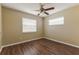 Inviting bedroom with wood-look floors, a ceiling fan, and natural light from two windows at 5822 Flori Ln, Orlando, FL 32808
