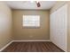 A clean bedroom with neutral walls, wood-style floors, a ceiling fan, and a double door closet at 5822 Flori Ln, Orlando, FL 32808