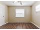 A bright bedroom with neutral walls, wood-style floors, a ceiling fan, and a window with blinds at 5822 Flori Ln, Orlando, FL 32808