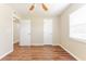 A bright bedroom featuring wood-style floors, a window, and two doors at 5822 Flori Ln, Orlando, FL 32808