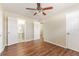Bright bedroom featuring wood floors, ceiling fan, and neutral paint, leading to an ensuite bathroom at 5822 Flori Ln, Orlando, FL 32808