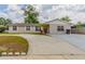 Charming single-story home with a wide driveway, red front door, and nicely landscaped front yard at 5822 Flori Ln, Orlando, FL 32808